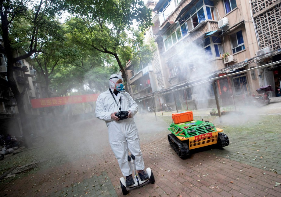 ROBOT kawalan jauh untuk menyembur pembasmi kuman digunakan di Wuhan. FOTO AFP 