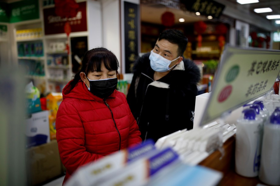 ORANG awam memakai penutup mulut dan hidung di farmasi di Beijing, China. FOTO Reuters.  