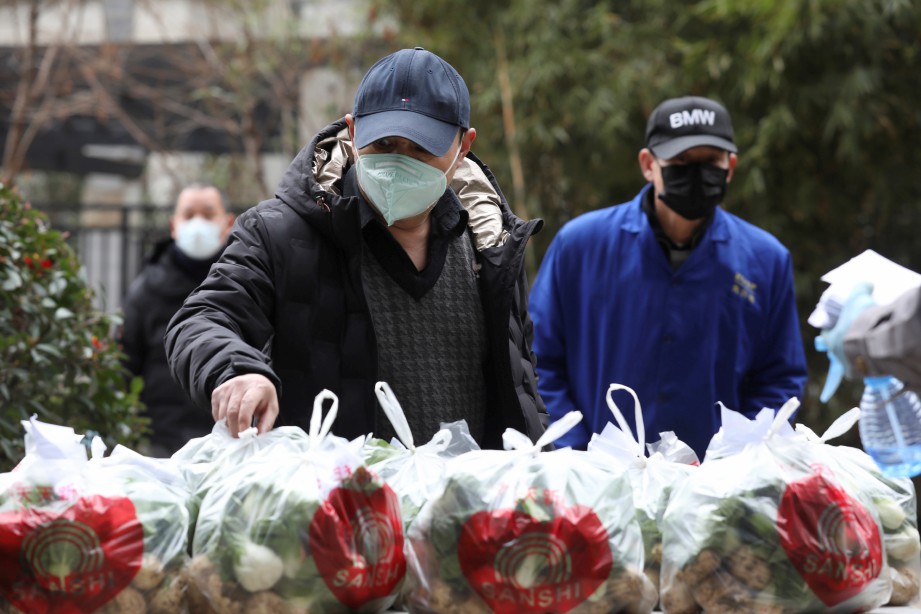 ORANG ramai memilih sayur percuma dibekalkan pekerja komuniti di sebuah kawasan perumahan di Wuhan, Hubei. FOTO China Daily/ Reuters. 