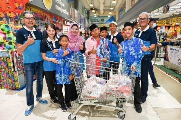 Pengerusi CIMB Group, Datuk Mohd Nasir Ahmad (pertama dari kanan), bersama Ketua Pegawai Eksekutif Kumpulan CIMB Group, Datuk Abdul Rahman Ahmad  (tiga dari kanan), bersama kanak-kanak dari rumah anak yatim ketika sesi membeli belah ‘Baju Raya’ di Mydin Subang Jaya.