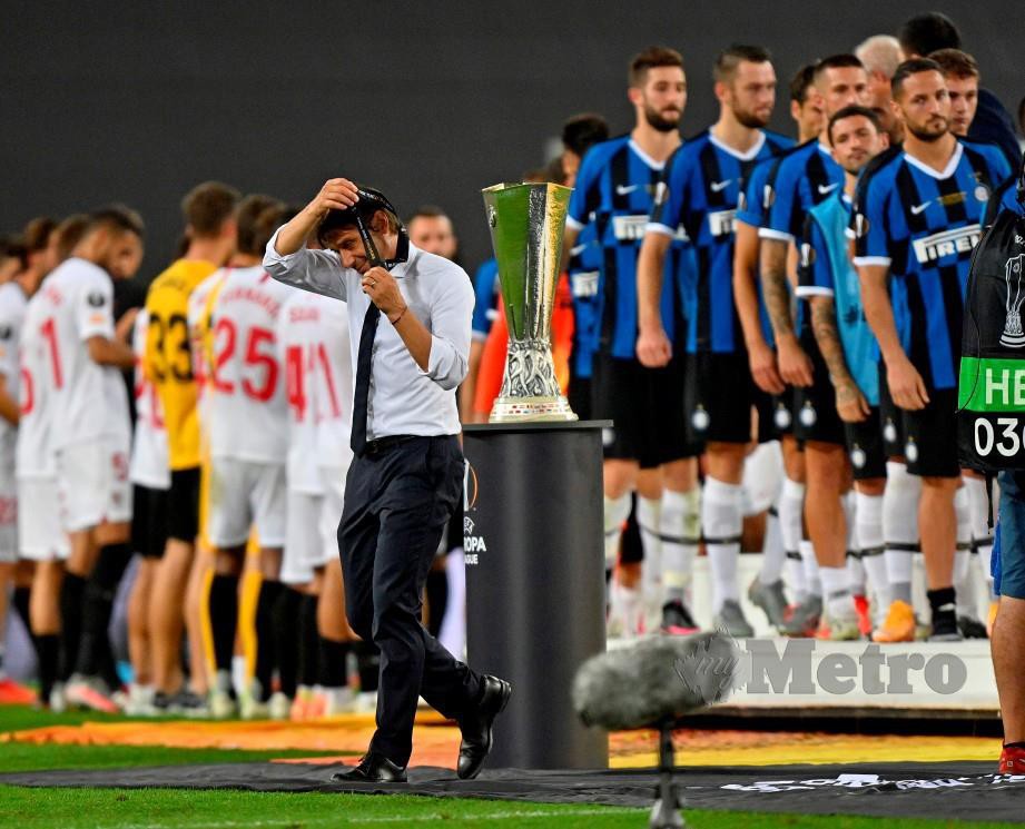 Conte menanggalkan pingat selepas berjalan melepasi trofi Liga Europa. FOTO AFP 