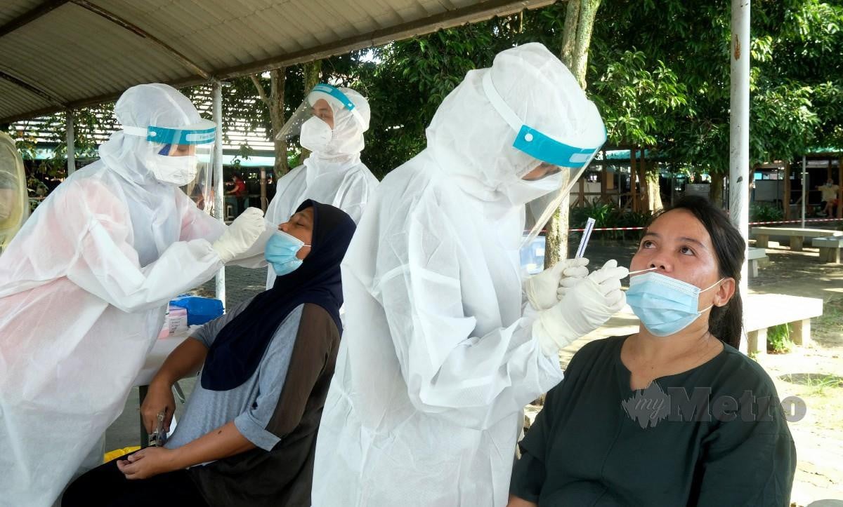 PETUGAS Unit Penyakit, Pejabat Kesihatan Sandakan mengambil sampel pengunjung dan peniaga di laluan pejalan kaki sewaktu mengadakan saringan Covid-19 di Pasar Kim Fung. FOTO Bernama 