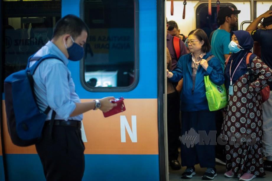 PENUMPANG LRT memakai penutup mulut dan hidung ketika menggunakan perkhidmatan. FOTO Arkib NSTP.