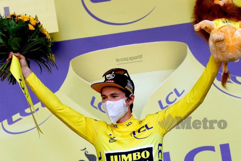 ROGLIC meraikan kejayaannya mempertahankan jersi kuning selepas tamat peringkat perlumbaan ke-14. FOTO AFP 