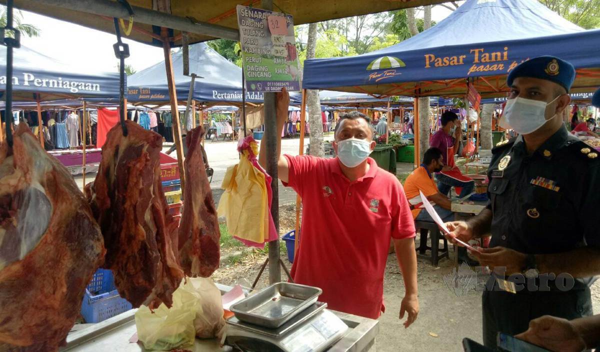 PEGAWAI penguatkuasa KPDNHEP memeriksa harga daging ketika melakukan tinjauan pematuhan harga barangan di Pasar Tani Hiliran. FOTO Baharom Bakar