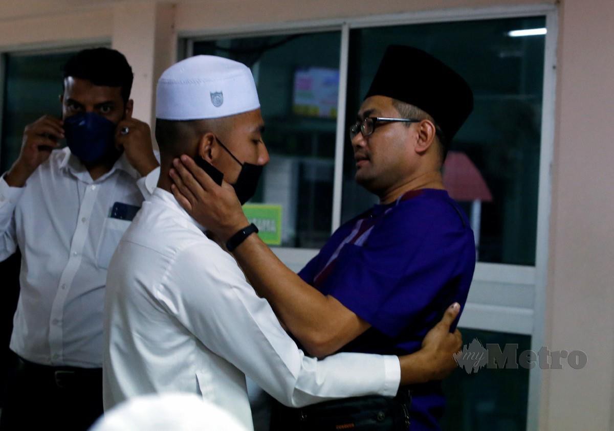 Daniel (kiri) dipeluk kariah Masjid Al Islaniah ketika pertemuan antara keluargannya dan pihak pengurusan masjid di Kuang hari ini. Foto Hairul Anuar Rahim 