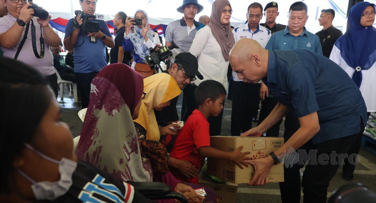 Armizan Mohd Ali menyampaikan Bakul Rahmah kepada pengunjung pada Program Jualan Rahmah Peringkat Negeri Pahang di Simpang Pelangai hari ini. FOTO BERNAMA