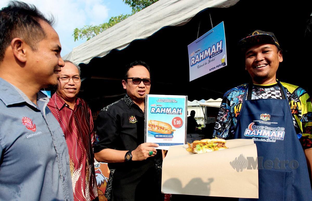 KAMALLUDIN (tiga, kiri) bersama peniaga Mohamad Haifi Naimy, 34, (kanan) menunjukkan roti mini John yang dijual pada harga RM5. FOTO Bernama 