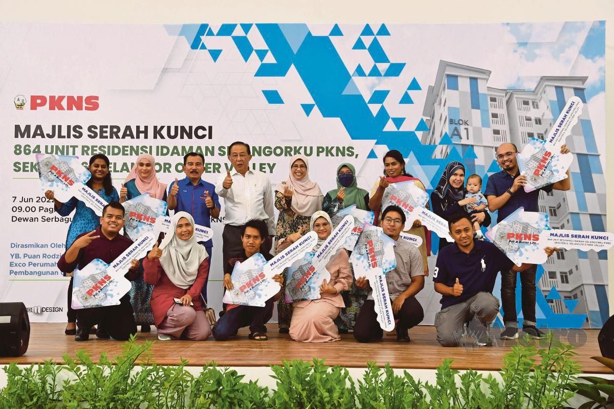 MAHMUD (berdiri empat dari kiri) dan Exco Perumahan dan Kesejahteraan Bandar serta Pembangunan Usahawan Negeri Selangor, Rodziah Ismail (berdiri tengah) bersama penerima kunci pada Majlis Serah Kunci 864 unit Residensi Idaman Selangorku PKNS.