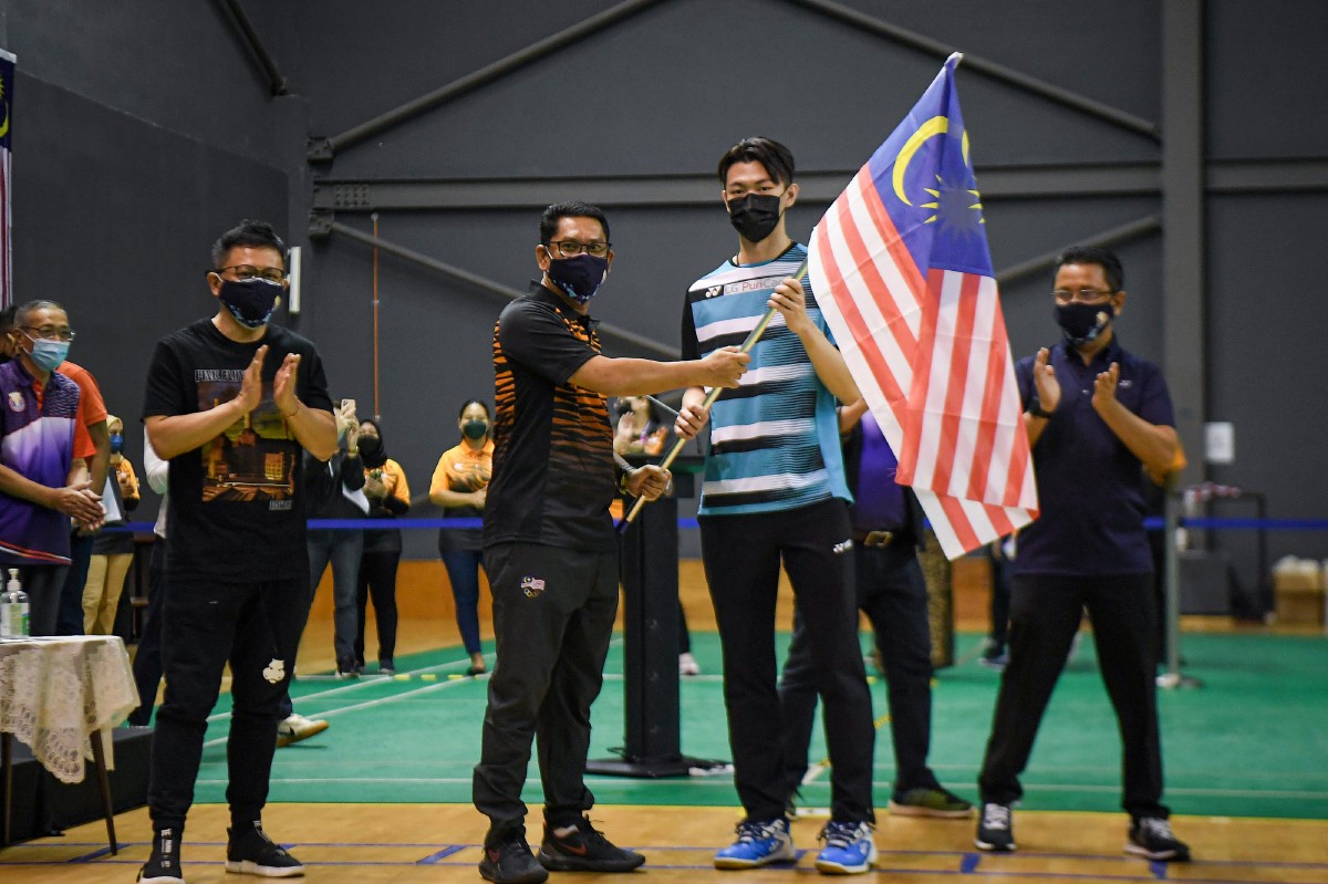 Menteri Belia dan Sukan Datuk Seri Ahmad Faizal Azumu menyerahkan Jalur Gemilang kepada Zii Jia (dua, kanan) ketika melawat ke Akademi Badminton Malaysia. FOTO Bernama