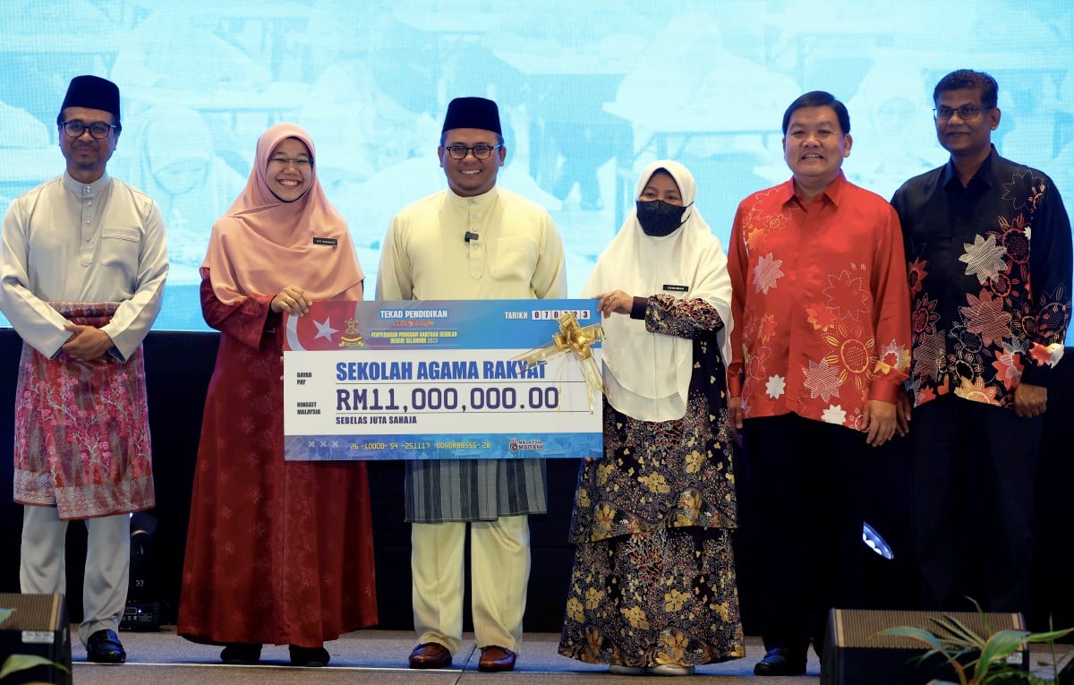 AMIRUDIN (tiga, kiri) menyampaikan bantuan sekolah kepada wakil Sekolah Agama Rakyat berjumlah RM11 juta. FOTO Bernama 