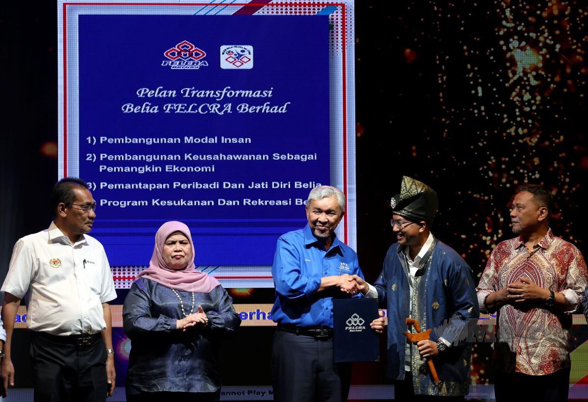 AHMAD Zahid bersalaman bersama Anugerah Ikon Versatile Generasi Kedua Felcra Berhad Mohd Nazri Rosli pada Majlis Apresiasi Generasi Kedua Felcra Berhad. FOTO Bernama 