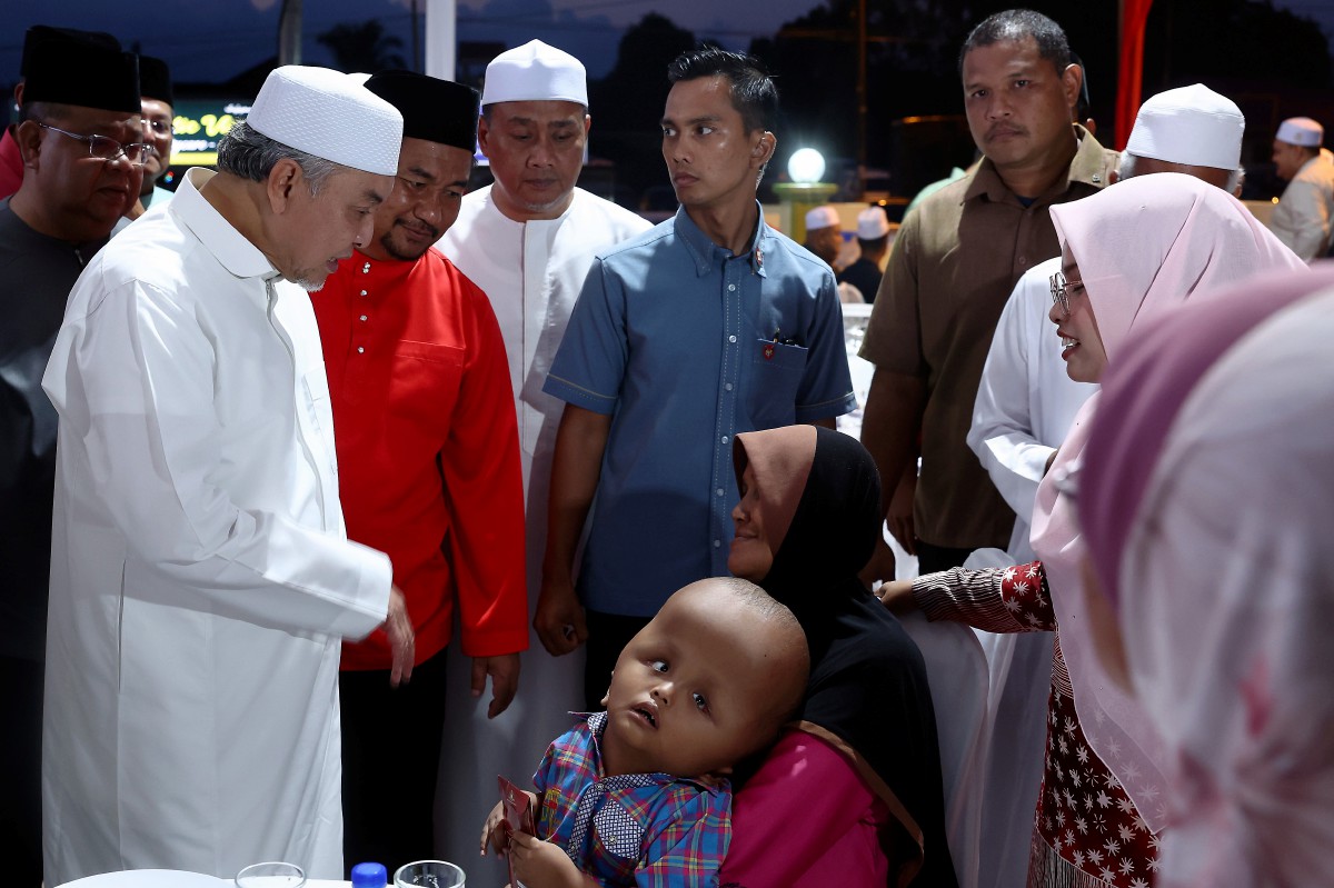 AHMAD Zahid menyantuni kanak-kanak Mohd Faris Ofran Zulkarnain. FOTO Bernama 