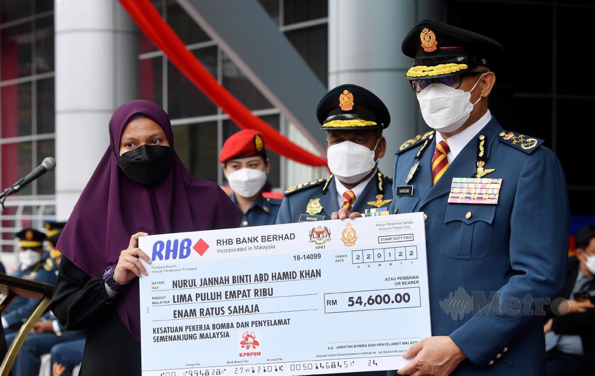 Ketua Pengarah Jabatan Bomba dan Penyelamat Malaysia (JBPM) Datuk Seri Mohammad Hamdan Wahid (kanan) menyampaikan sumbangan replika cek bernilai RM54,600 kepada Jannah di Ibu Pejabat JBPM. FOTO BERNAMA