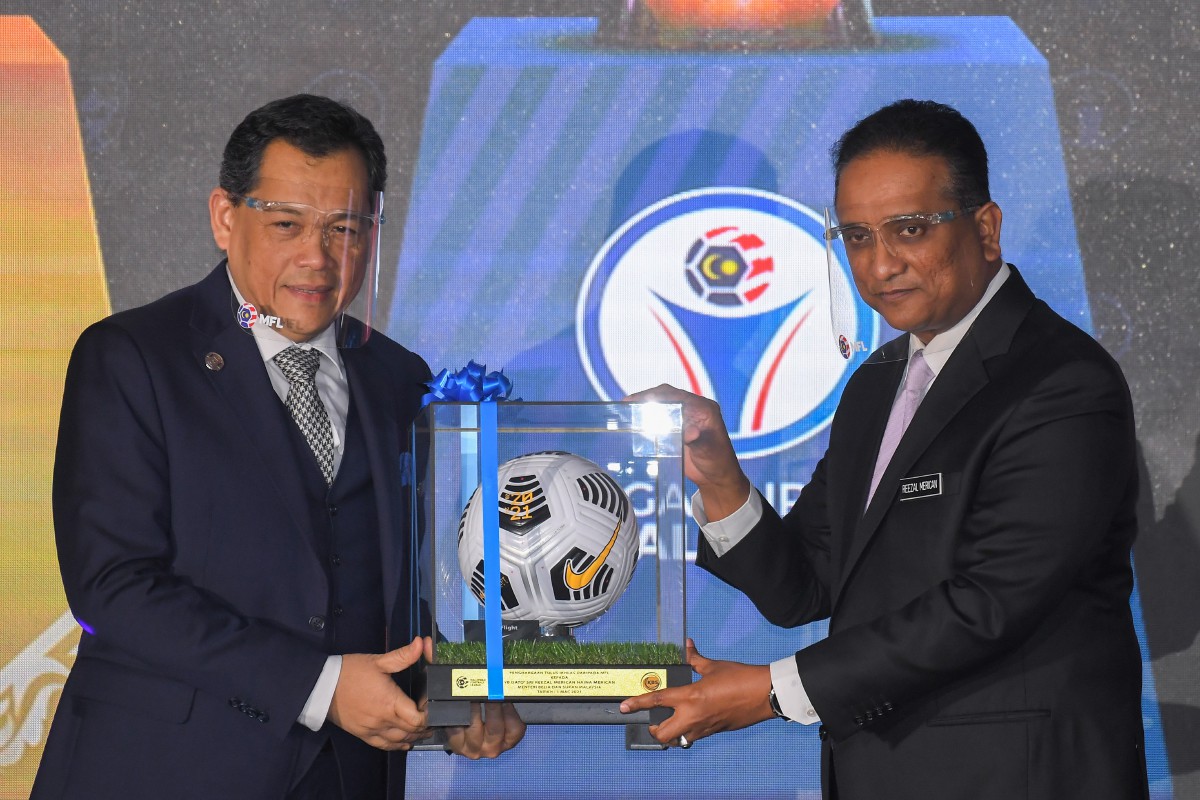 Reezal Merican (kanan) menerima cenderahati daripada Presiden MFL Datuk Hamidin Mohd Amin selepas merasmikan majlis pelancaran Liga Malaysia 2021 hari ini. FOTO Bernama