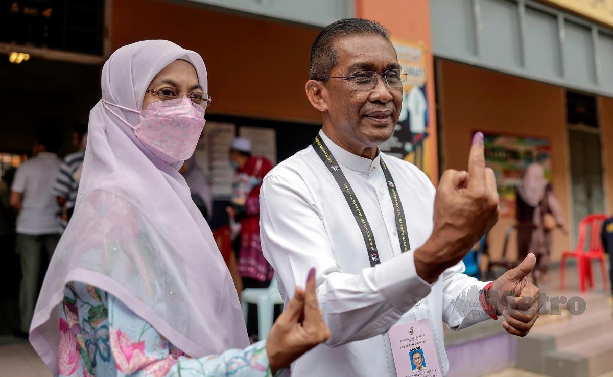 Takiyuddin Hassan bersama isteri menunjukkan jari masing-masing  selepas menunaikan tanggungjawab mengundi. FOTO BERNAMA