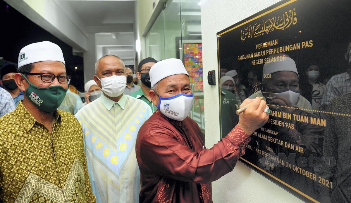 TUAN Ibrahim (kanan) diiringi Ahmad Yunus (kiri) menandatangani plak perasmian Bangunan Pas Selangor di Seksyen 13 Shah Alam hari ini. FOTO Bernama