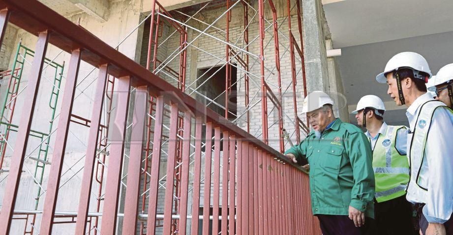 JAAFAR (kiri) memeriksa tapak pembinaan kondominium di Jalan Pantai Sinaran, Georgetown, semalam.