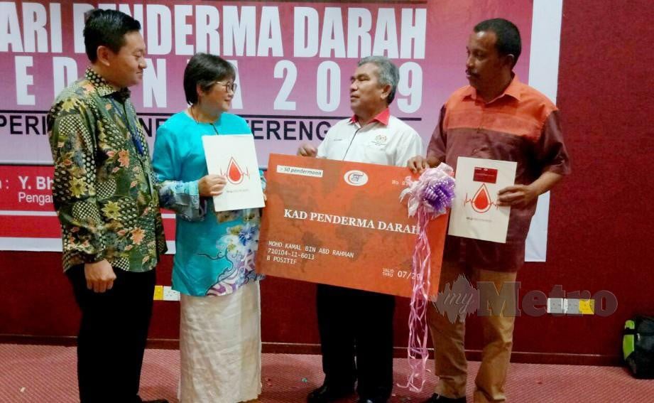 Dr Mohd (dua dari kanan) dan Dr Mohd Muhaimin (kiri)  meraikan Mohd Kamal (kanan) dan Geok Lan di majlis Hari Penderma Darah Sedunia peringkat negeri di Auditorium HSNZ, Kuala Terengganu, hari ini. Foto Baharom Bakar 