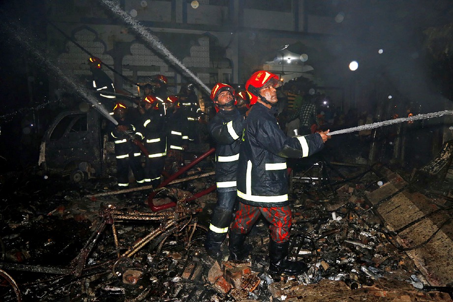 ANGGOTA bomba dan orang ramai cuba memadam kebakaran di Chawk bazar. FOTO Reuters