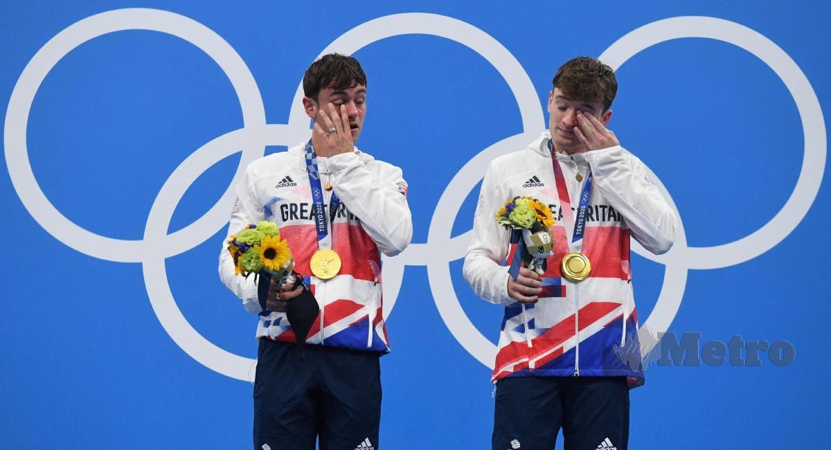 DALEY (kiri) dan Lee tidak dapat menahan sebak selepas berjaya meraih emas acara terjun 10m platform seirama. FOTO AFP