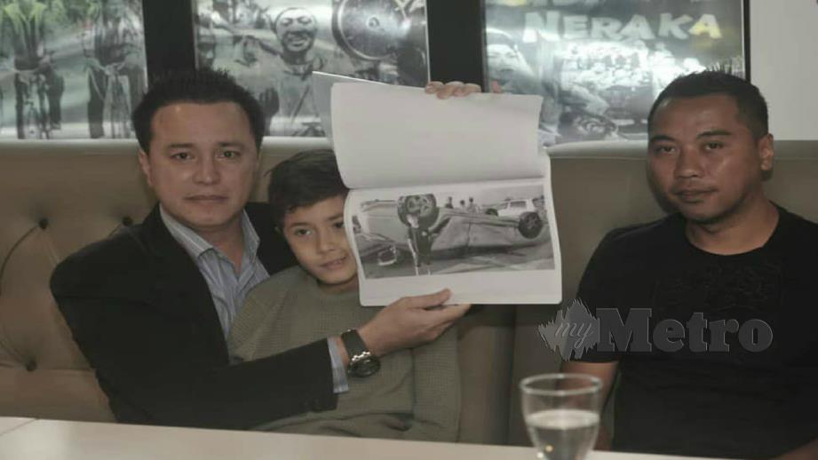 EIZLAN (kiri) menunjukkan gambar kemalangan kereta yang menimpa anaknya, Zareef Yusof sambil diperhatikan Pengarah Drama Mak Cun, Mohd Izuan Mohd Mokhtar. FOTO Khairul Azhar Ahmad