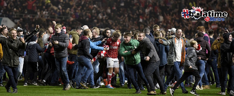 PENYOKONG menceroboh padang selepas tamat perlawanan antara United dan Bristol City untuk meraikan kemenangan mereka. -Foto EPA