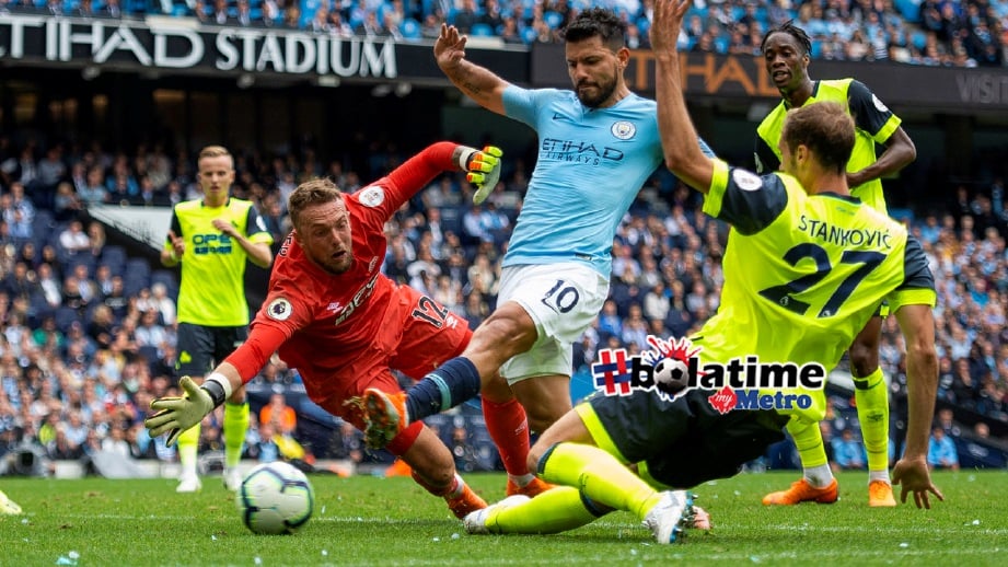 SERGIO Aguero (tengah) menjaringkan gol ketiga dalam perlawanan antara Manchester City dan Huddersfield Town di Manchester. FOTO EPA
