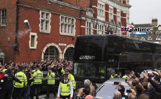 Pasukan polis mengawal bas membawa pemain Manchester United yang dibaling objek. FOTO AP