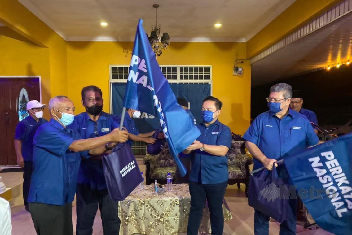 WAN Saiful (dua dari kanan) menyerahkan bendera PN kepada wakil Bersatu Muar sebagai simbolik pelancaran jentera PRN Johor di Muar. FOTO Essa Abu Yamin