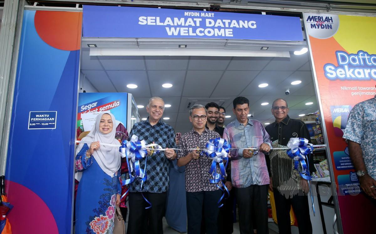 FAHMI diiringi Pengarah Urusan Mydin Mohamed Holdings Bhd, Datuk Ameer Ali Mydin (dua dari kiri) memotong riben ketika majlis perasmian dan penyerahan Sumbangan Aidiladha di Mydin Mart Pantai Dalam, Kuala Lumpur. FOTO Hairul Anuar Rahim