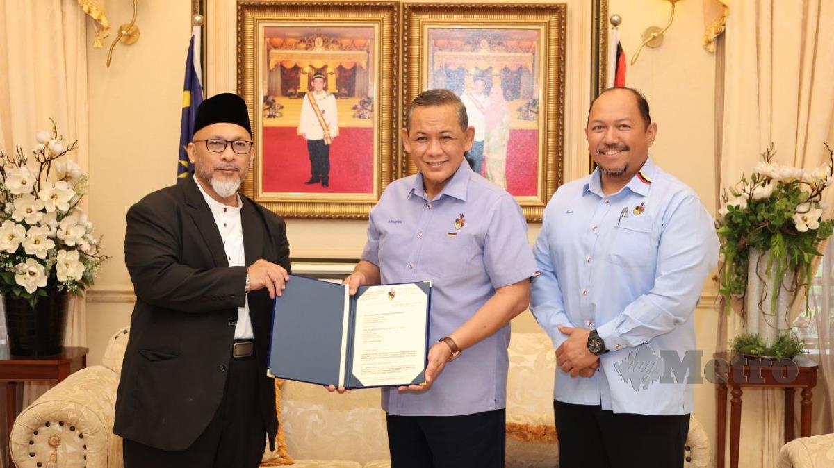 Aminuddin Harun (tengah) menunjukkan surat pelantikan Prof Madya Dr Mohd Faudzinaim Badarudin (kiri) sebagai Mufti Negeri Sembilan disaksikan Setiausaha Kerajaan Negeri, Datuk Mohd Zafir Ibrahim. Foto Ihsan Pejabat MB.