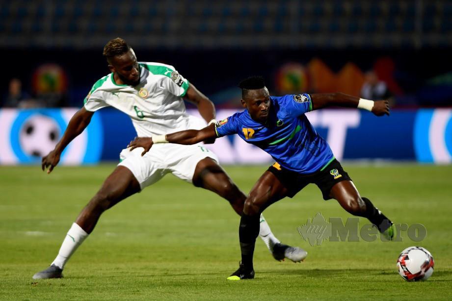 Pertahanan Senegal, Salif Sane (kiri) cuba menghalang pemain Tanzania pada aksi Piala Negara Afrika. FOTO AFP