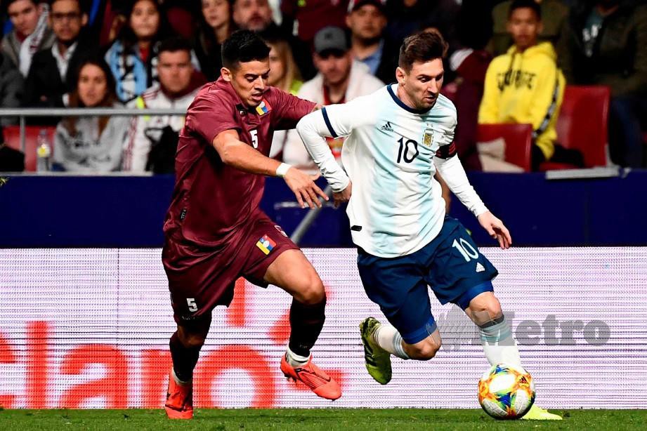 PERTAHANAN Venezuela, Yordan Osorio (kiri) mengasak Messi di Stadium  Wanda Metropolitano. - FOTO AFP