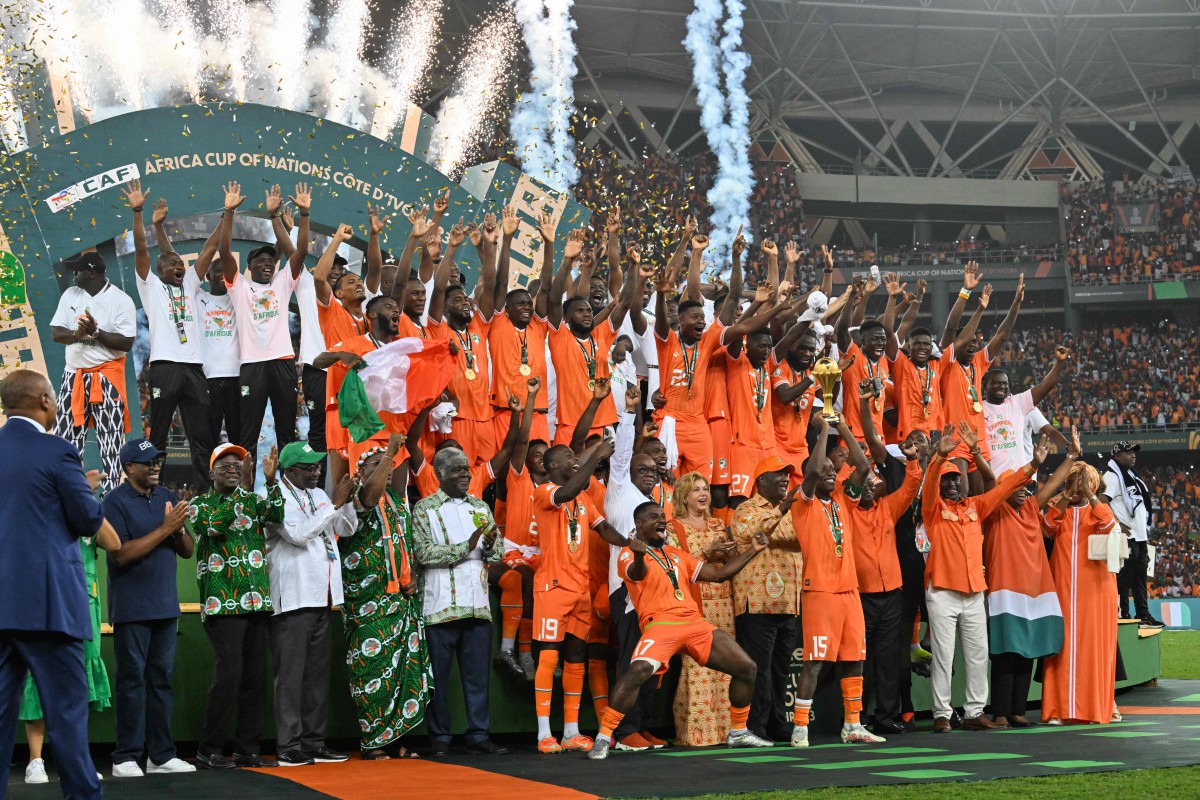 Ivory Coast's forward #15 Max-Alain Gradel lifts the Africa Cup of Nations trophy on the podium after Ivory Coast won the Africa Cup of Nations (CAN) 2024 final football match between Ivory Coast and Nigeria at Alassane Ouattara Olympic Stadium in Ebimpe, Abidjan on February 11, 2024. (Photo by Issouf SANOGO / AFP)