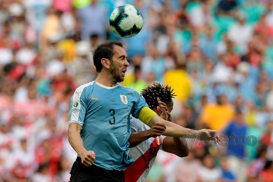 Aksi pemain Uruguay Diego Godin (kiri) ketika perlawanan menentang Peru pada Copa America baru-baru ini. FOTO AFP