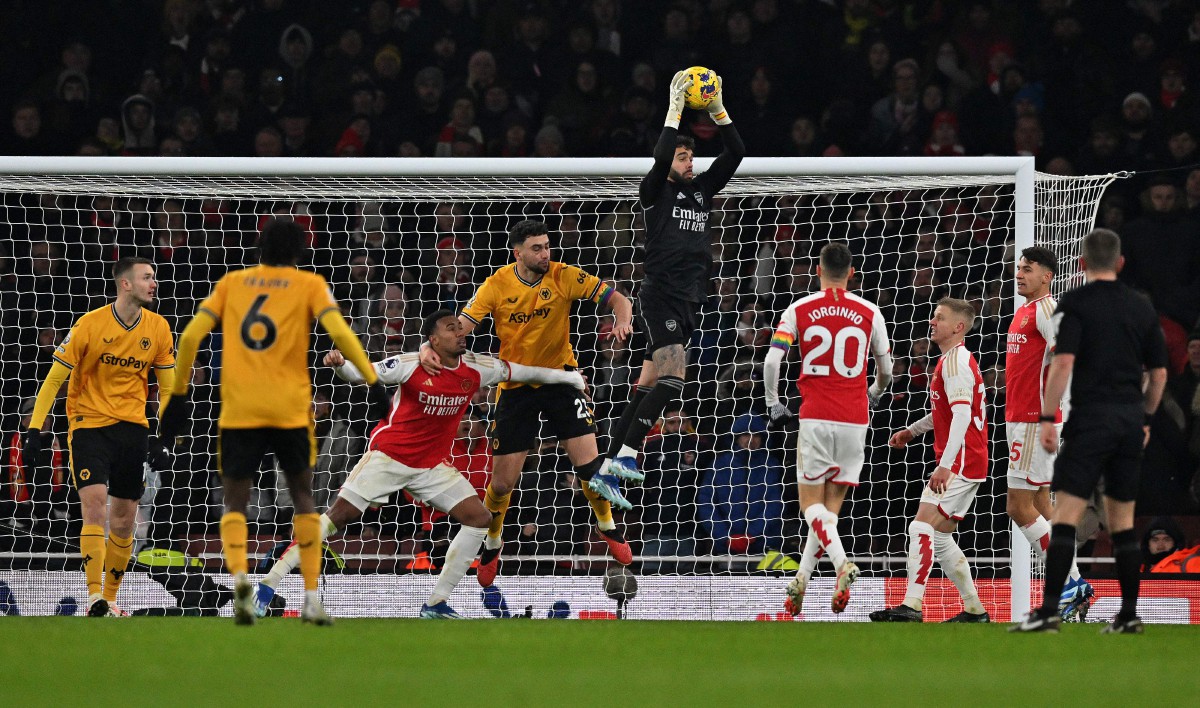 PENJAGA gol Arsenal David Raya melompat untuk menyelamatkan serangan dari pemain Wolves. -FOTO AFP 