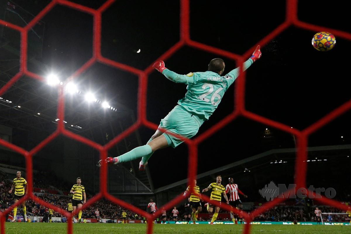 Penjaga gol Watford, Daniel Bachmann cuba menyelamatkan gawang ketika bertemu Brentford. FOTO AFP