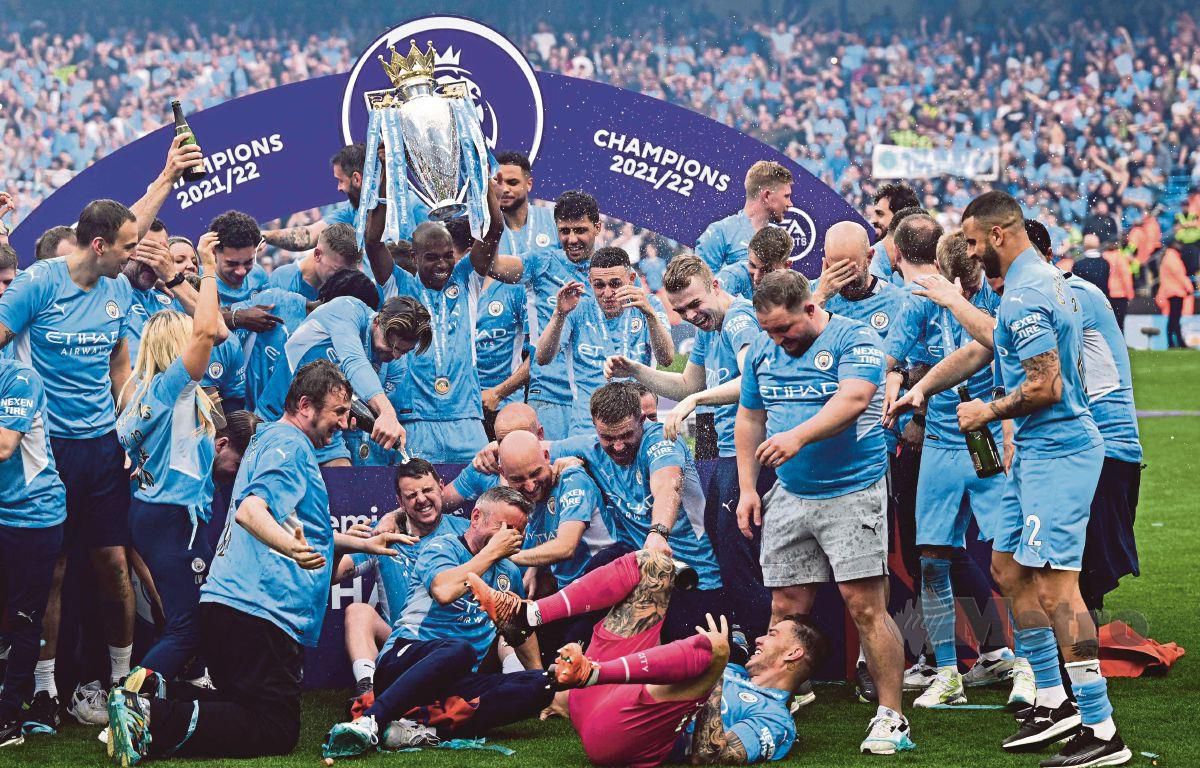 PEMAIN Manchester City menjulang trofi dan meraikan kejayaan mengekalkan gelaran Liga Perdana Inggeris. FOTO AFP