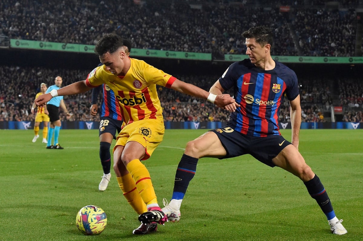 LEWANDOWSKI (kanan) berebut bola dengan pemain pertahanan Girona, Arnau Martinez pada perlawanan La Liga, semalam. FOTO REUTERS 