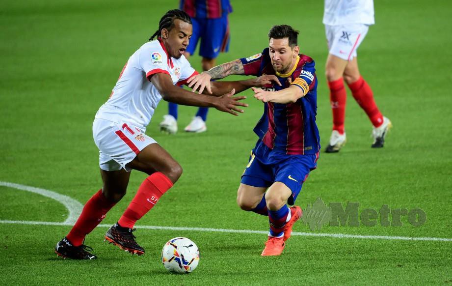 LIONEL Messi (kanan) cuba melepasi Jules Kounde dalam perlawanan yang menyaksikan kedua-dua pasukan terikat 1-1. FOTO AFP