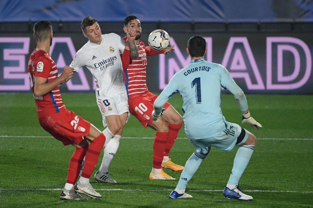 PEMAIN tengah Real Madrid Toni Kroos (dua dari kiri) dikawal ketat pemain Granada. FOTO AFP 