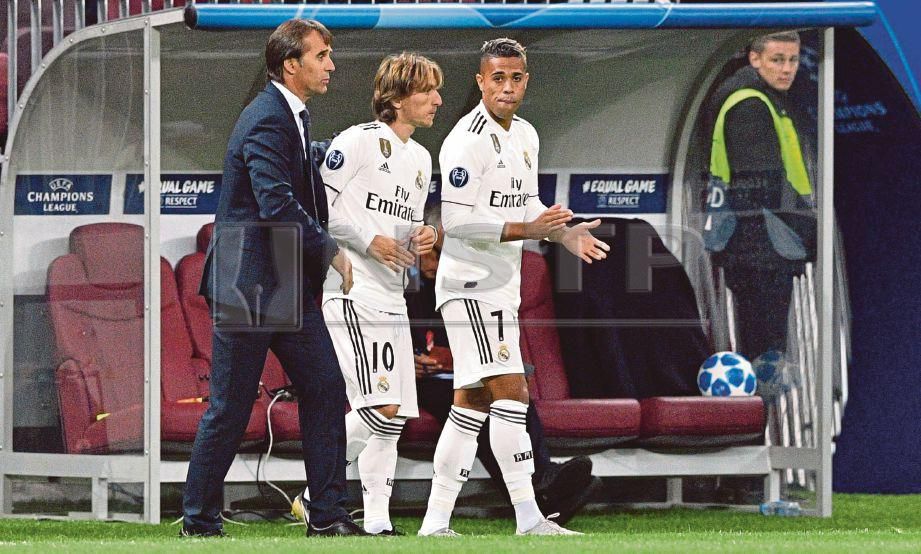 PENGURUS Real Madrid, Julen Lopetegui (kiri) membawa masuk Luka Modric pada aksi Liga Juara-Juara. FOTO AFP