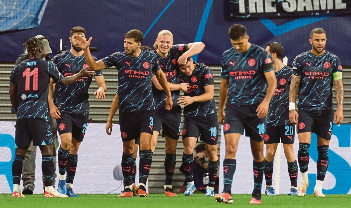 HAALAND (empat dari kiri) memeluk Alvarez selepas menjaringkan gol pendahuluan untuk City. FOTO AFP 