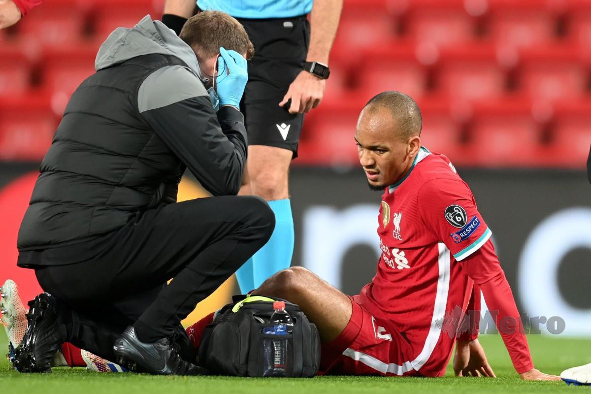 Pemain Liverpool, Fabinho (kanan) menerima rawatan selepas mengalami kecederaan pada aksi Liga Juara-Juara. FOTO AFP