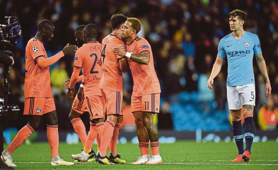 PEMAIN Manchester City, John Stones (kanan) hanya mampu melihat keceriaan pemain Lyon yang berjaya menewaskan City 2-1. FOTO AFP