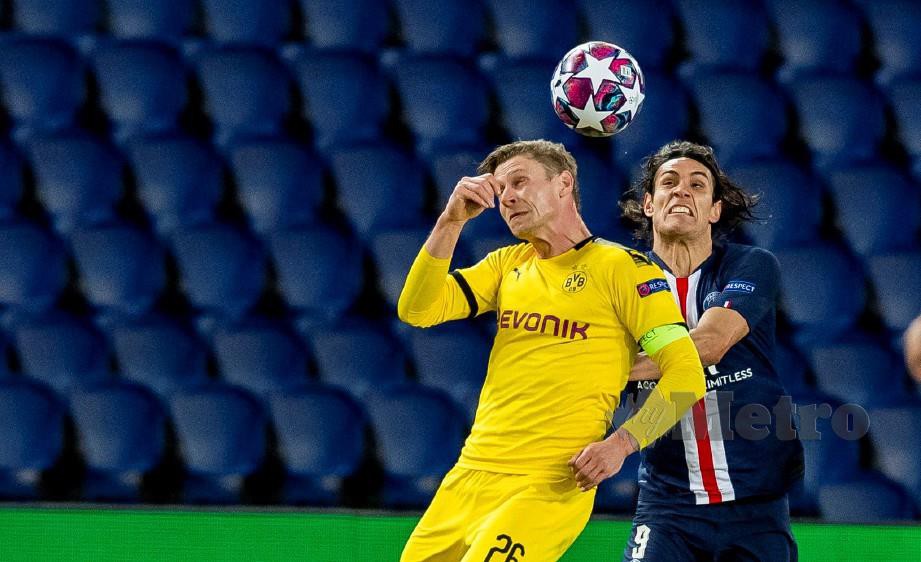 Pemain Dortmund, Lukasz Piszczek (kiri) bersaing merebut bola dengan penyerang PSG, Edinson Cavani. FOTO AFP