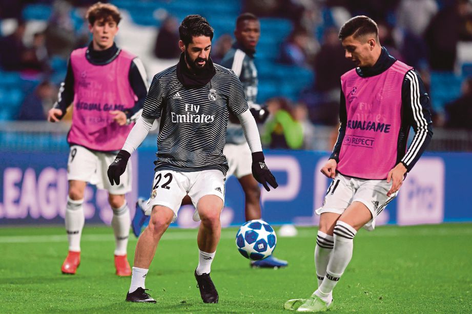 Real Madrid's Spanish midfielder Isco (C) warms up before the UEFA Champions League group G football match between Real Madrid CF and CSKA Moscow at the Santiago Bernabeu stadium in Madrid on December 12, 2018. (Photo by JAVIER SORIANO / AFP)
