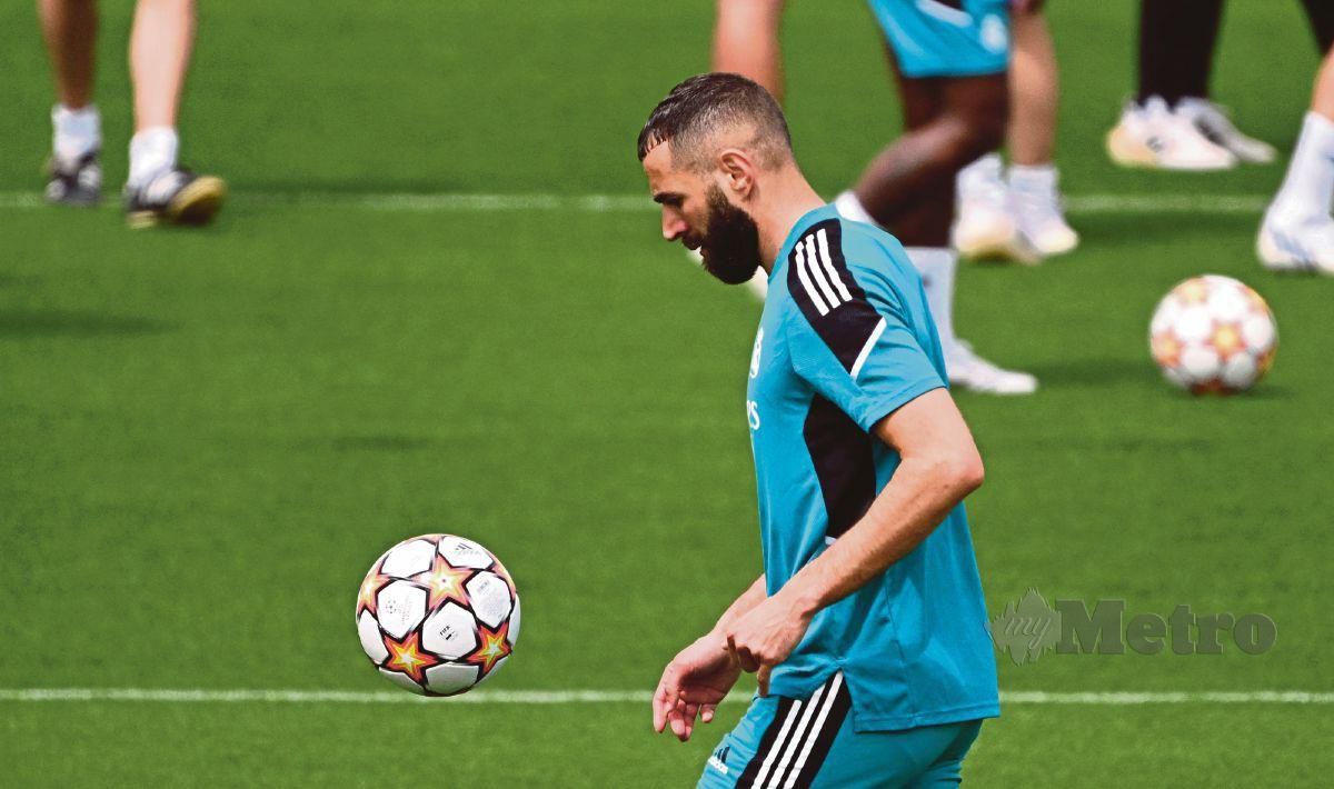 PENYERANG Real Madrid, Karim Benzema menimang bola pada sesi latihan di Ciudad Real Madrid. FOTO AFP