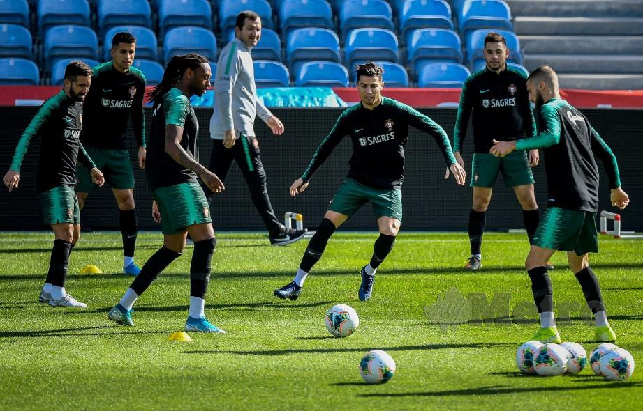 RONALDO (tengah) memanaskan badan bersama  pemain Portugal di Stadium Algarve, Faro. - FOTO AFP  